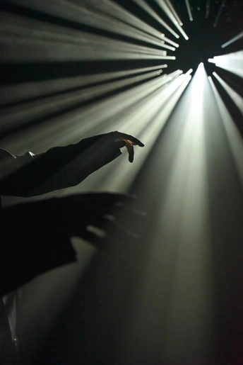 一个人在舞台上伸手去拿灯