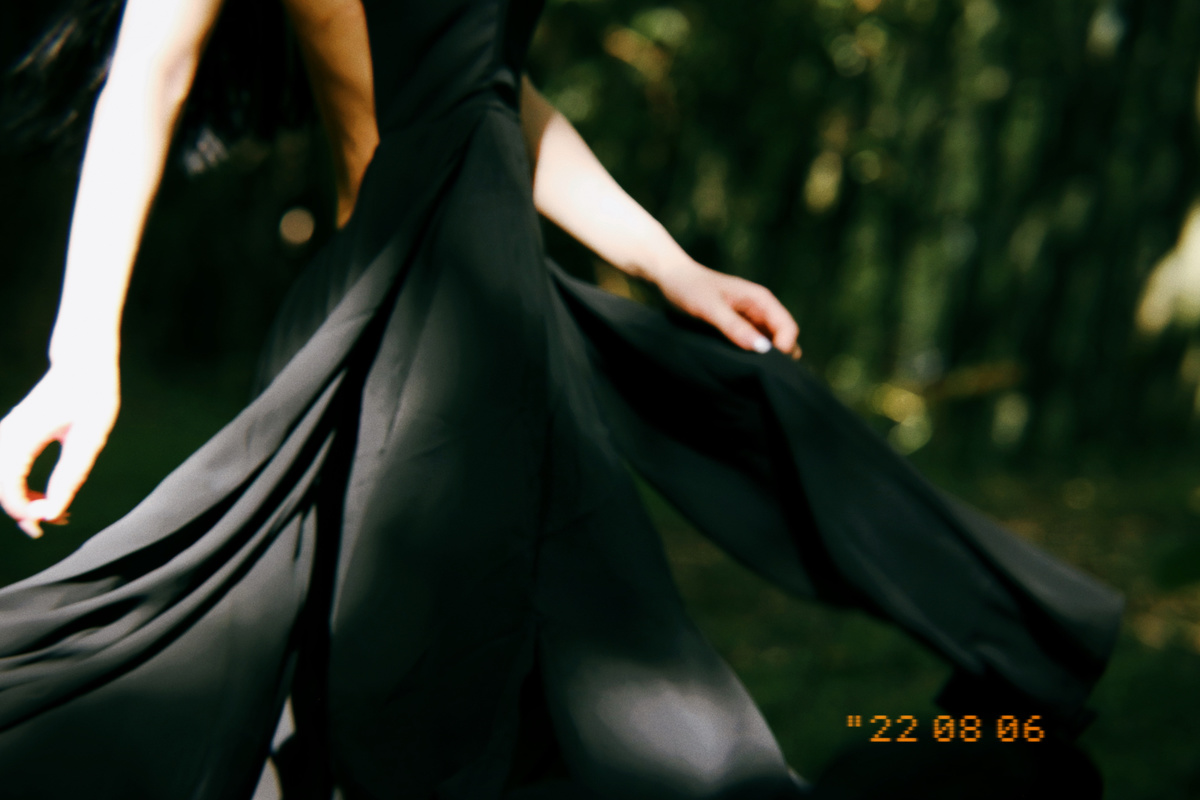 一个女孩在树林里穿着黑色长裙 打着伞