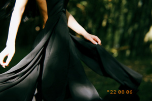 一个女孩在树林里穿着黑色长裙 打着伞