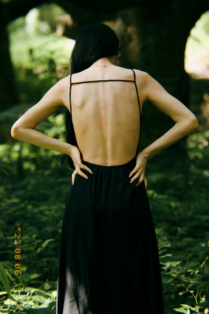 一个穿着黑色连衣裙的女人穿过森林