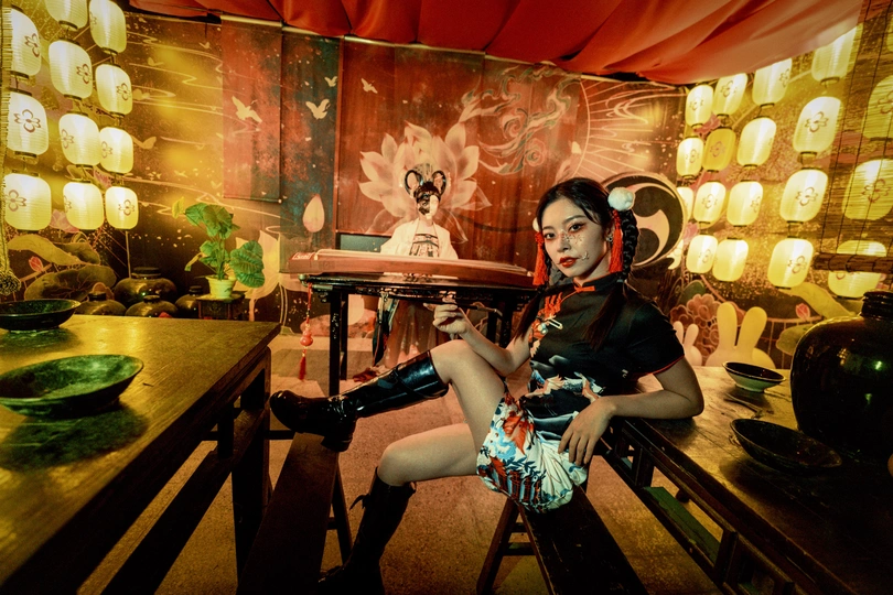 一个年轻女子坐在带有桌子和椅子的房间里的一张长椅上