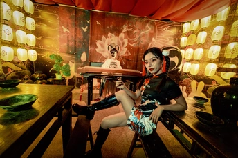 一个年轻女子坐在带有桌子和椅子的房间里的一张长椅上