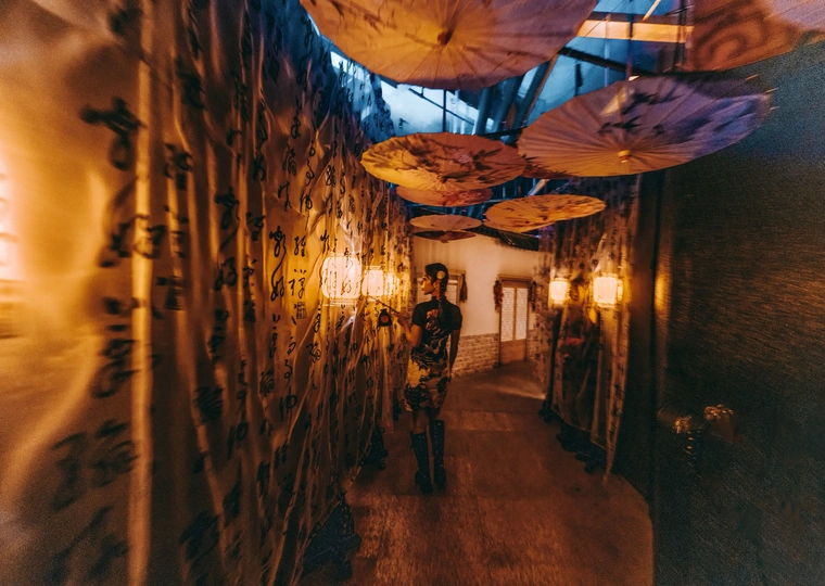 挂有伞的狭长隧道 房间的墙壁上有灯光