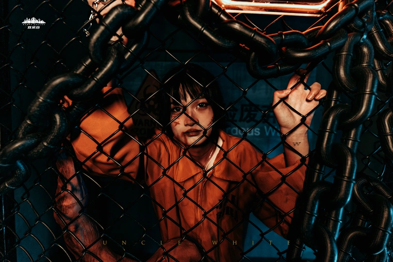 一张年轻男孩站在铁丝网后面挥着棒球棒的图片