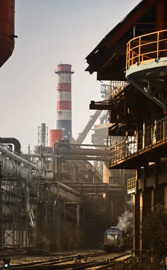 蓝色火车在靠近工厂的铁路轨道上行驶