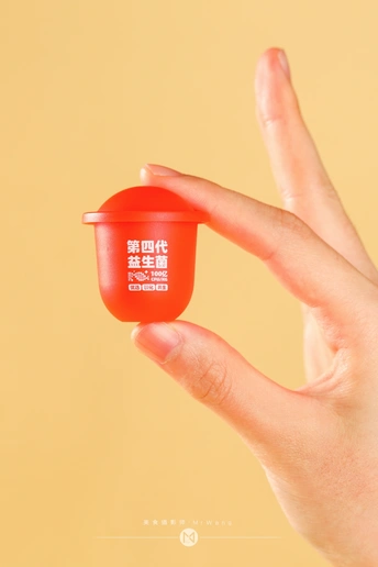 黄色背景下拿着红杯子的手