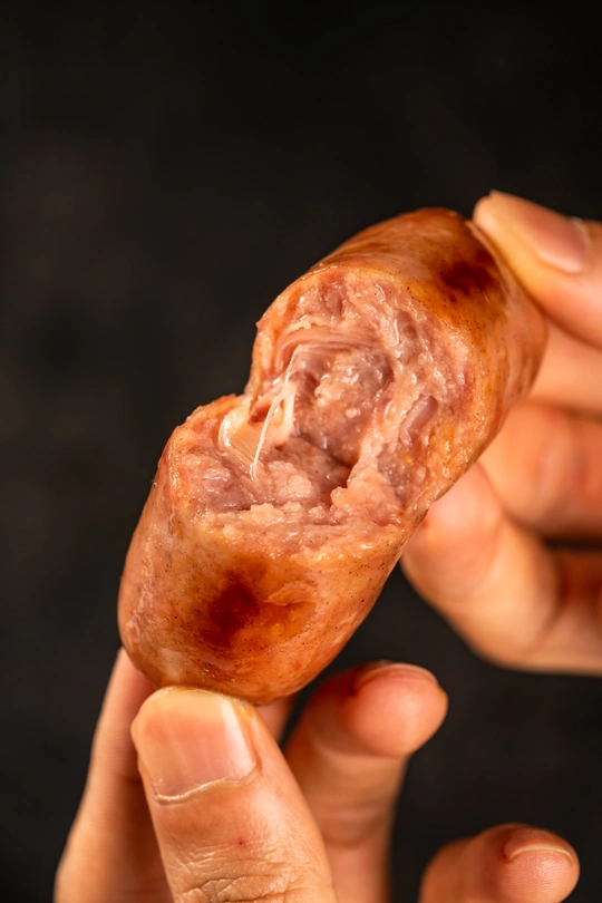 手里拿着肉和香肠的糕点的人