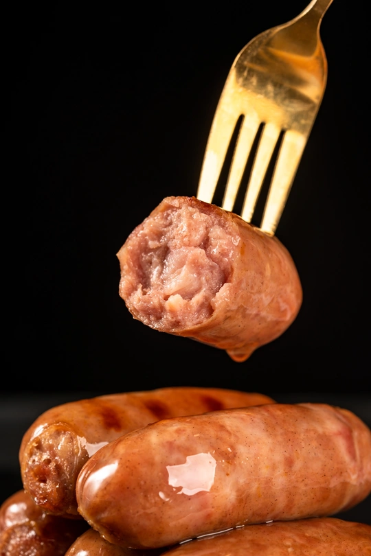 从一堆香肠里伸出来的金叉子