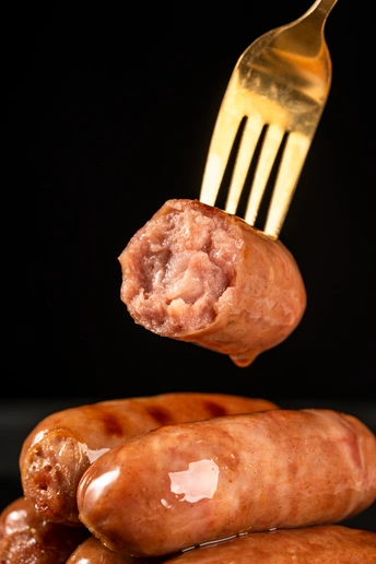 从一堆香肠里伸出来的金叉子