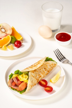 一个带有食物的白色桌子 其中包括一个鸡蛋、蔬菜和一些酱汁。
