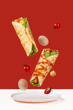 一片披萨 上面有奶酪、番茄和鸡蛋 掉落在红色的背景上的白色盘子上。