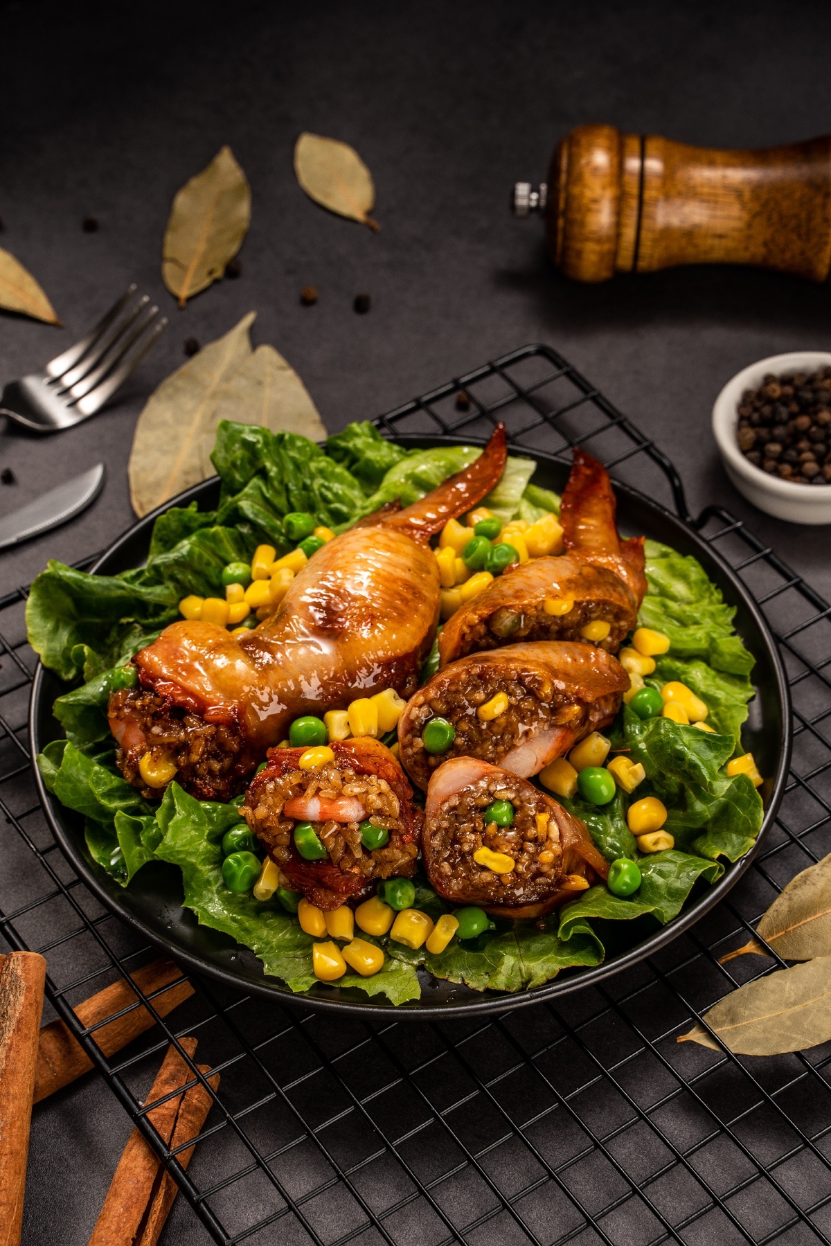 一份鸡肉、玉米和豌豆沙拉 放在生菜叶上的一块黑盘子。