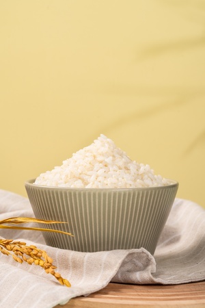 一碗白米饭和一些小麦粒在木桌上