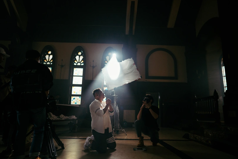 一个人在教堂里用相机拍一个光线昏暗的房间。