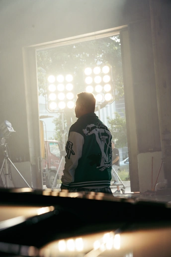 一个坐在窗户前的人 向外看 房间光线昏暗。