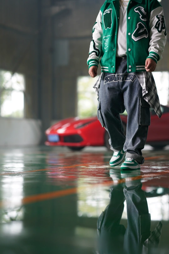 一个年轻男孩站在停车场 地上有一辆红色的车。