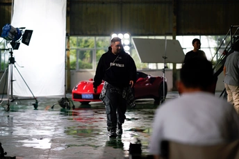 一个人走向一辆红色的运动车在摄影棚里