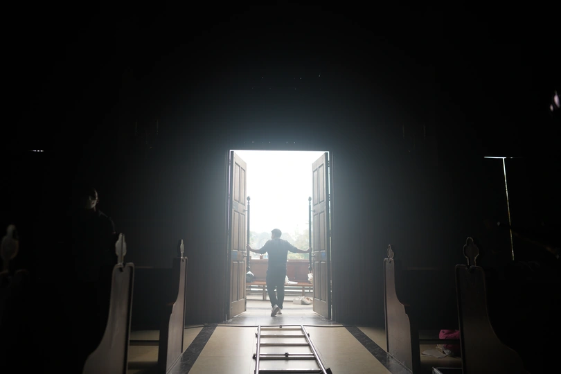 一条长长的走廊 门开着通向一个黑暗房间里的明亮光线。