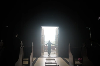 一条长长的走廊 门开着通向一个黑暗房间里的明亮光线。