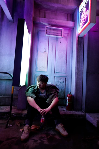 一个年轻人坐在一栋建筑物的台阶上