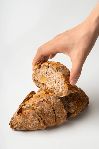 一位女性手拿一片面包在白色背景上