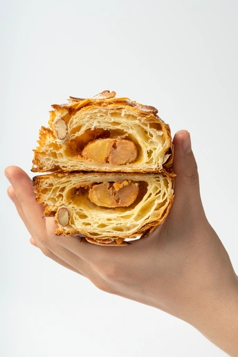 一个人手里拿着有肉和香肠的点心