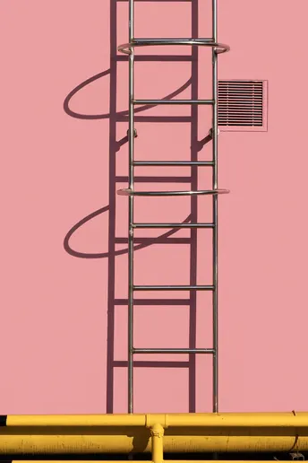 粉红色墙壁上有黄色管道和一座粉色天空中的塔。