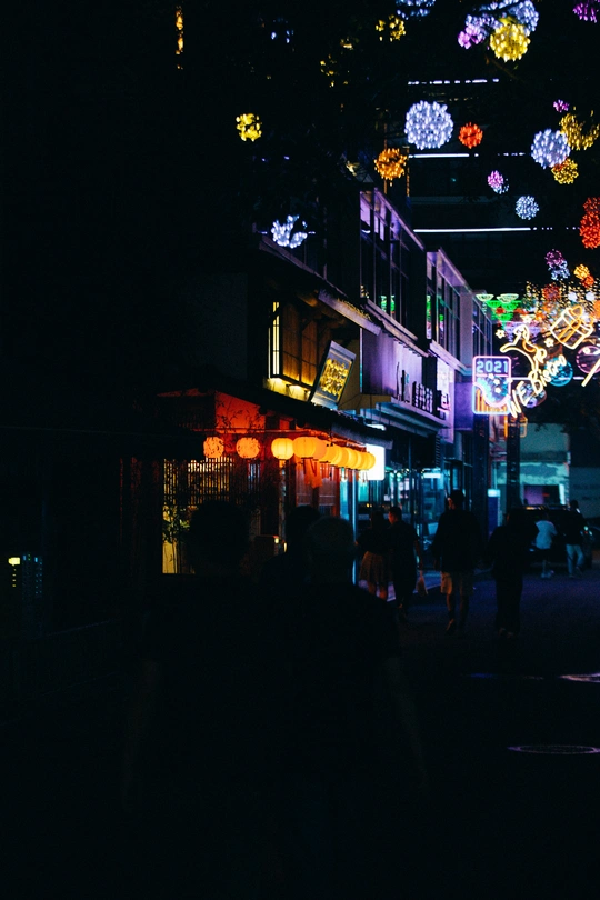 人们晚上走在黑暗的城市街道上