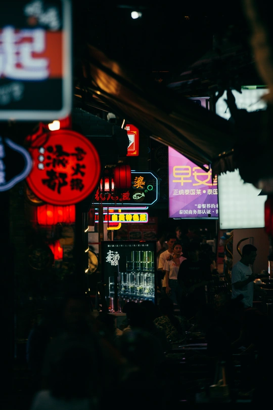 夜晚的黑暗街道 人们在黑暗的房间里 建筑物上挂着霓虹灯