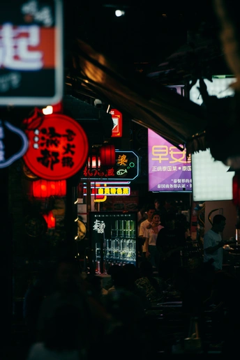 夜晚的黑暗街道 人们在黑暗的房间里 建筑物上挂着霓虹灯