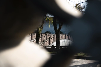 通过桥围栏上的一个洞拍照的人