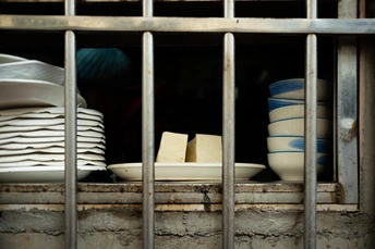 吧台后面有盘子、碗和杯子。