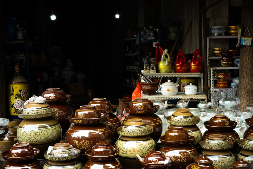 商店里的桌子上有许多花瓶和花瓶。