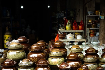 商店里的桌子上有许多花瓶和花瓶。