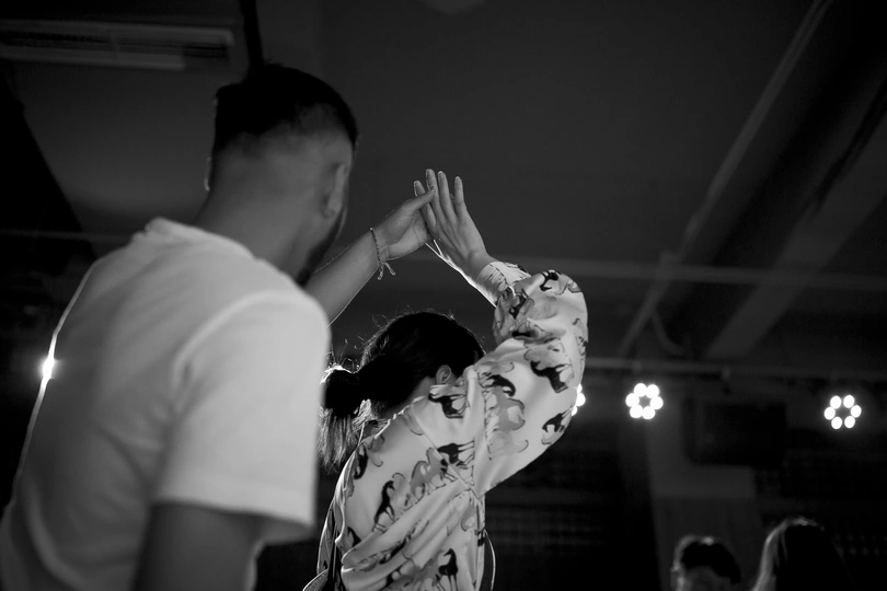 黑白照片 一对男女在脸前舞动手臂