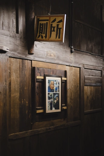 一座有木墙和门 上面挂着海报和标志的老房子