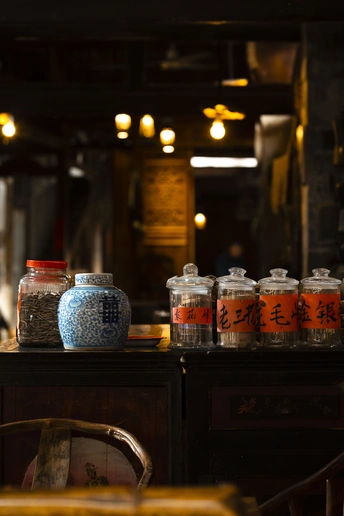 一个带有桌子、椅子、书架和上面放着罐子的柜台房间。