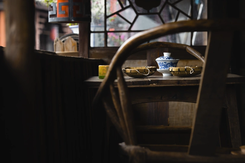 一个带有木制桌子、椅子和蓝色白色碗的窗户的房间