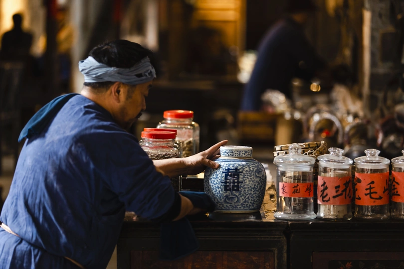 站在桌子前的男子 桌子上放着罐子。