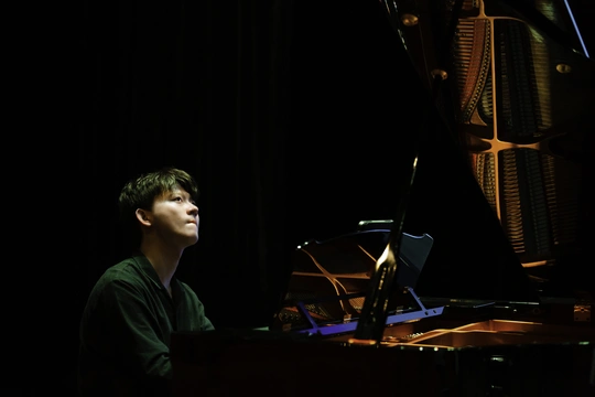 一个年轻男子在黑暗的房间里舞台上演奏乐器