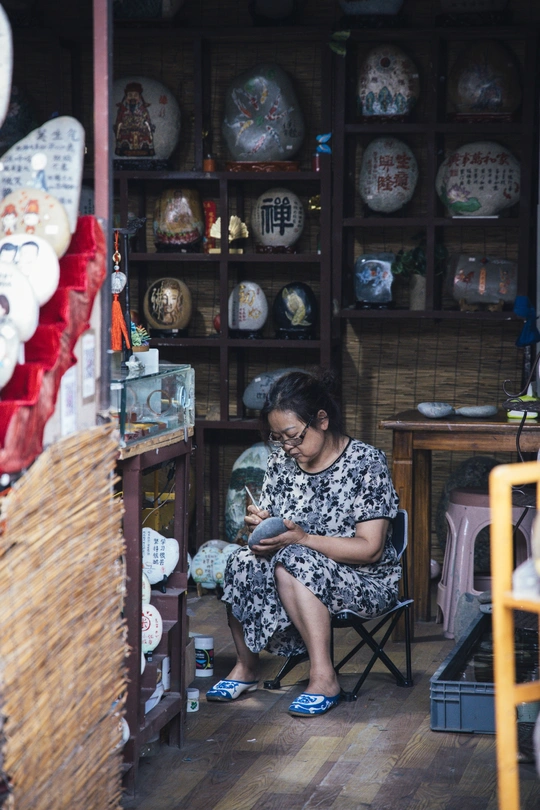 一位年轻女士坐在一个房间里 一个人正在打电话。