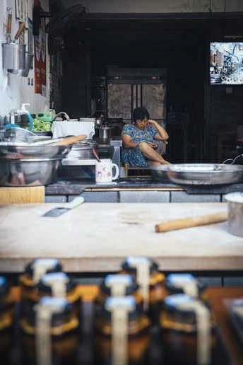 一位妇女站在厨房的柜台前准备食物
