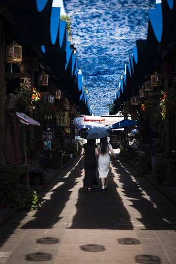 一对夫妇拿着雨伞走在一个小巷子里