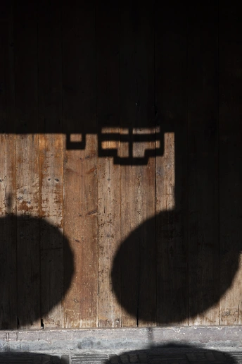 一些人站在一个有阴影的木材墙前