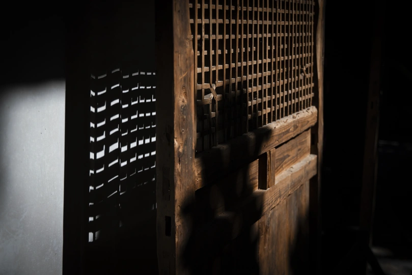 一个黑暗的房间 门是木制的 墙上有些许阴影。