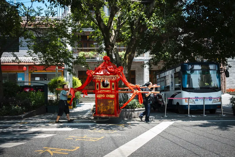 人们走在红巴士旁边的街道上