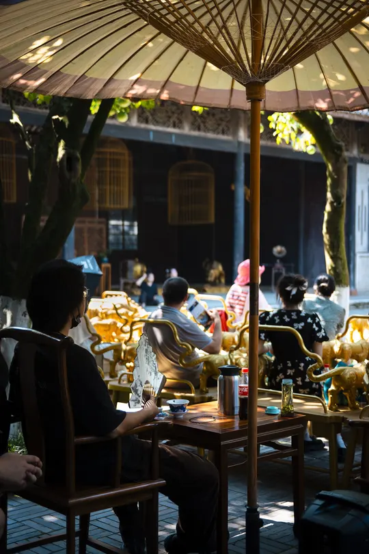 一个男子和一个女子坐在夜晚的露天餐厅里 桌子上有遮阳伞。