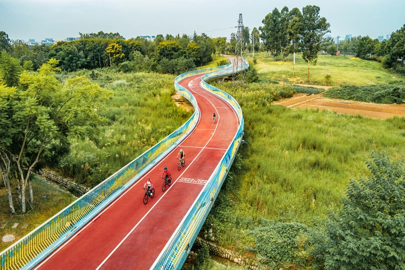 人们在蜿蜒的道路上骑自行车的鸟瞰图 骑自行车的人在路上奔跑