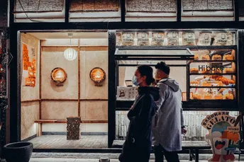 一个男人和一个女人站在商店前面 晚上看着餐厅的窗户。