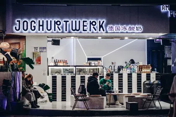 人们在夜晚坐在餐厅外面的桌子旁